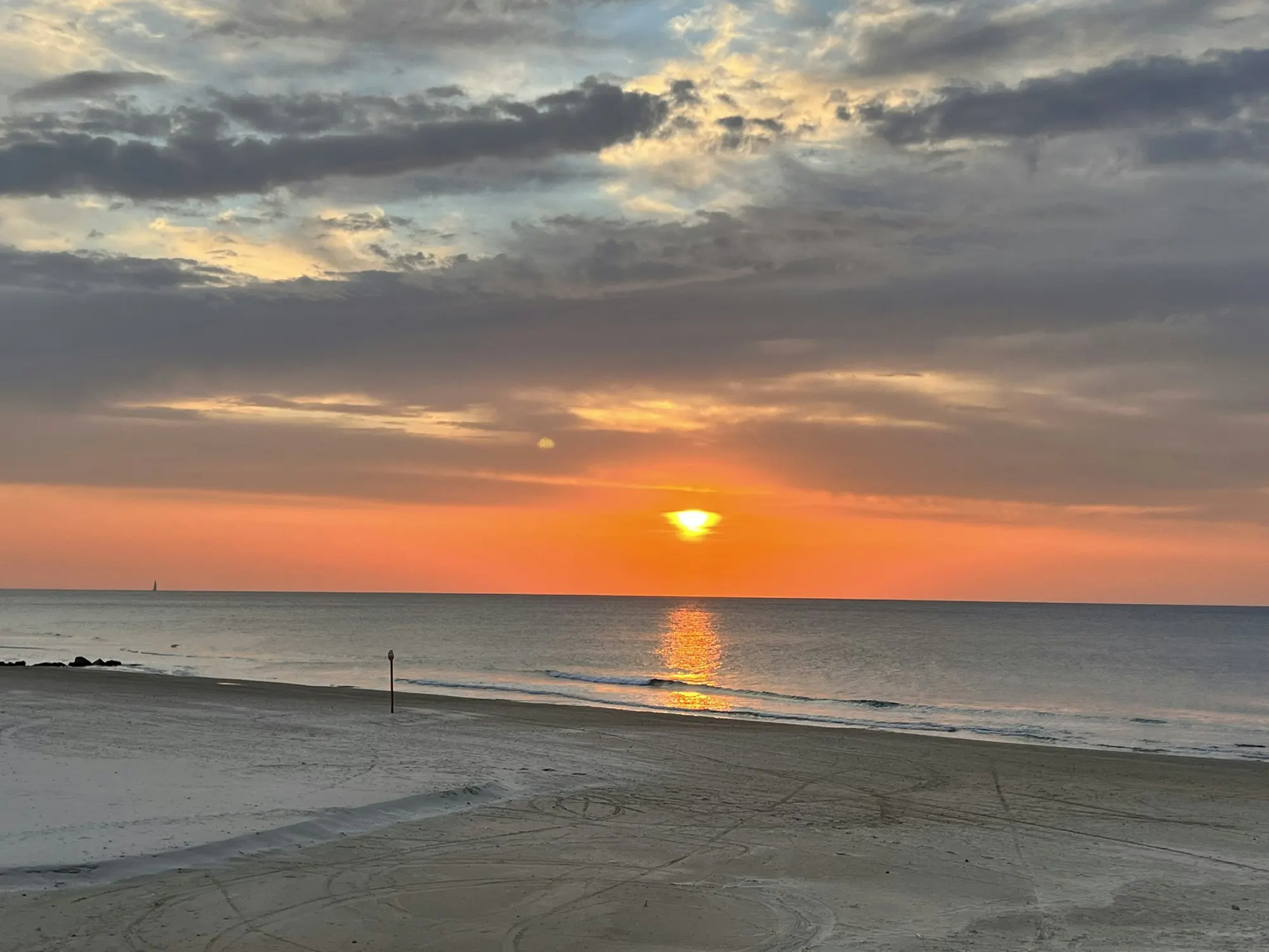 Le soleil couchant sur la mer, depuis la plage